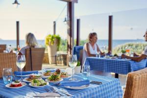 a table with plates of food and glasses of wine at TUI Magic Life Candia Maris - Adults Only in Amoudara Herakliou