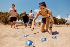 a woman playing with beach balls in the sand at TUI Magic Life Candia Maris - Adults Only in Amoudara Herakliou