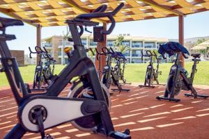 a row of exercise bikes parked under ailion at TUI Magic Life Candia Maris - Adults Only in Amoudara Herakliou