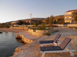 twee ligstoelen naast een lichaam water bij Apartments Perla in Dinjiška