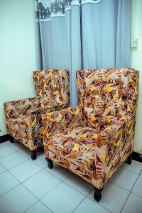 a flowered chair sitting in a room at Travellers Home near Mlimani City Mall with free parking in Dar es Salaam