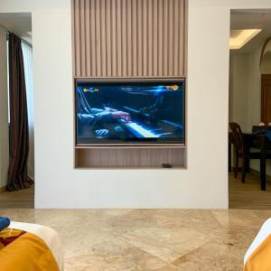 uma sala de estar com televisão numa parede branca em Lorin Beach Resort em Sijuk
