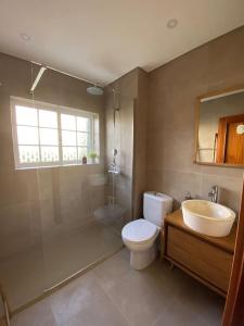 a bathroom with a sink and a toilet and a tub at Nini Beach House in Aroeira