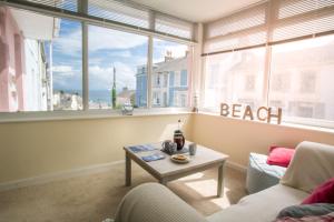 a living room with a couch and a table in front of a window at Ellesmere New Quay in New Quay