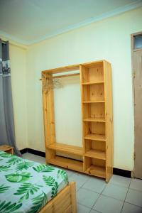 a room with a bed and a book shelf at Travellers Home near Mlimani City Mall with free parking in Dar es Salaam