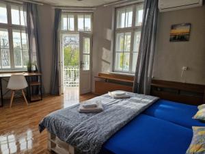 una camera da letto con un letto blu con due asciugamani sopra di Lambo's Corner Varna - Guest Rooms a Varna