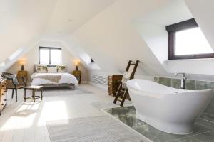 a bathroom with a bath tub and a bedroom at Herons Nest in Ripple