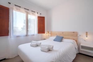 ein Schlafzimmer mit einem großen weißen Bett mit zwei Kissen in der Unterkunft Can Pubila white beach in Santanyi
