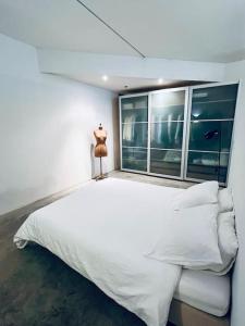 een slaapkamer met een groot wit bed en een raam bij Loft Antwerp - Eilandje in Antwerpen