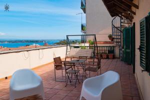 a patio with a table and chairs on a balcony at Rooftop Madreperla in Taranto