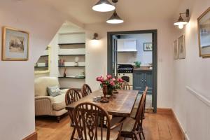 uma cozinha e sala de jantar com mesa e cadeiras em Alexis Cottage Tetbury Cotswolds em Tetbury