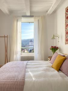 a bedroom with a large bed with a large window at Le Coucou Montcuq in Montcuq