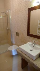 a bathroom with a sink and a toilet and a mirror at Casa de Ladreda in Tangil +53 photos