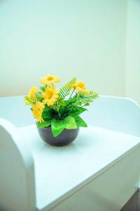 a vase filled with yellow flowers sitting on a table at Travellers Home near Mlimani City Mall with free parking in Dar es Salaam