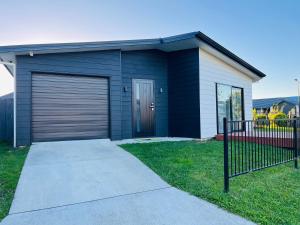 a house with a garage with a driveway at Modern Comfy 3 Bedrooms House in Chartwell in Hamilton