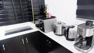 a kitchen counter with a coffee maker and a microwave at 2BR near BGC & Makati. Karaoke, Netflix, Amazon Prime in Manila