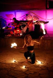 Eine Frau auf einer Bühne mit Feuer in der Unterkunft Babakamp Eco Ranch & Retreat in Muğla