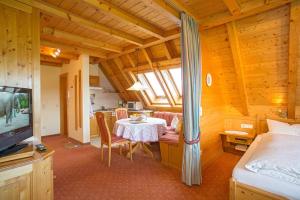 a room with a table and a bed and a television at Ferienhaus Esche in Hinterzarten
