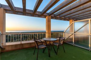 a table and chairs on a balcony with a view of the ocean at Costablanca Explore Hostel Sports & Events in La Marina