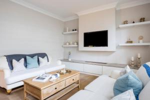 sala de estar con sofá blanco y TV en Elm Park Apartment - 2 Bed Chelsea Apartment, en Londres