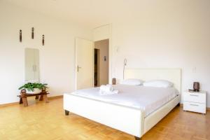 um quarto com uma cama branca e um espelho grande em Tourelle 2 - Spacieux appartement dans le centre de Genève em Genebra