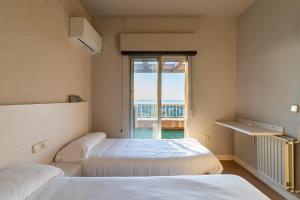 two beds in a room with a window at Costablanca Explore Hostel Sports & Events in La Marina