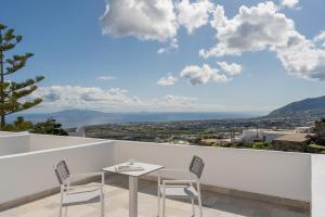 Una mesa y sillas en el balcón de una casa. en Santorini Palace, en Fira