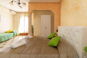 ジャルディーニ・ナクソスにあるVilla Cavallaroのベッドルーム1室(緑と白の枕が備わる大型ベッド1台付)