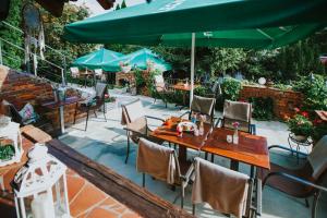 古賓的住宿－Pokoje gościnne LECH，一个带桌椅和绿色遮阳伞的庭院