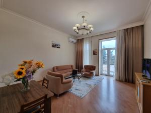 a living room with chairs and a table with a laptop at Malakan apartment in Baku