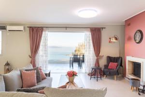 a living room with a view of the ocean at Beachfront Artemida Retreat - Peony Seabreeze Gem in Artemida