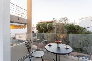 a small table and chairs on a balcony at Beachfront Artemida Retreat - Peony Seabreeze Gem in Artemida