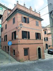 un vieux bâtiment rose sur le côté d'une rue dans l'établissement Sofia Casa Vacanze, à Osimo