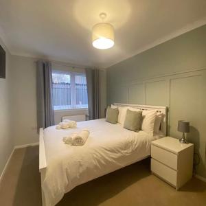 a bedroom with a white bed and a window at Cathwill - Cosy 4 Star Cottage - Cairngorm National Park in Newtonmore