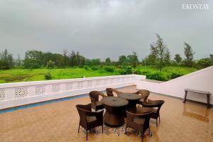 a patio with a table and chairs on a balcony at EKOSTAY- Nest Villa in Karjat