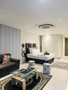 a bedroom with a bed and a couch and a table at Sibaya Umhlanga Apartments in Umhlanga