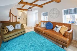 a living room with a brown leather couch and a blue rug at Host & Stay - The Snug in Hunmanby