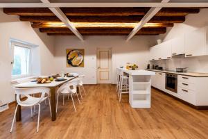 - une cuisine avec des placards blancs, une table et des chaises dans l'établissement Pepenero Camera con Vista, à Pavia dʼUdine