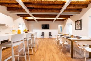 - une cuisine et une salle à manger avec des tables et des chaises blanches dans l'établissement Pepenero Camera con Vista, à Pavia dʼUdine