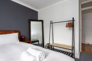 a bedroom with a white bed and a mirror at GuestReady - Cosy nest with balcony in London in London