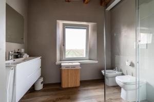 La salle de bains est pourvue de toilettes, d'un lavabo et d'une fenêtre. dans l'établissement Pepenero Camera con Vista, à Pavia dʼUdine