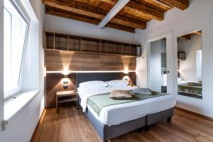 - une chambre avec un grand lit et une tête de lit en bois dans l'établissement Pepenero Camera con Vista, à Pavia dʼUdine
