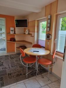 a small kitchen with a table and four chairs at ILMHOFpension in Bad Berka