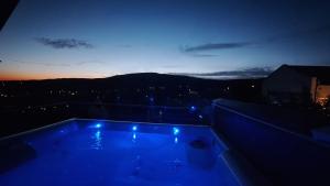 uma vista nocturna para uma piscina no telhado em Hillside Cottage em Pécs