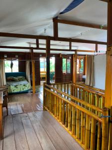 una camera con letto e ringhiera in legno di NASRUL HOUSE HOMESTAY FOR BACKPACKERS a Maros