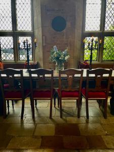 The Crown at Shipton في Shipton under Wychwood: طاولة وكراسي في غرفة بها نوافذ