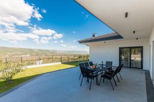 een patio met een tafel en stoelen en uitzicht bij Villa Lauret in Grubine