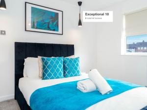 a bedroom with a bed with blue and white pillows at Five Bedroom & Five Bathroom House - Netflix - WIFI - Garden - Off-Street - Parking 376M in Birmingham