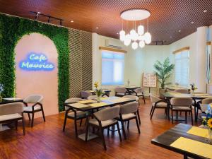 un restaurante con mesas y sillas y una pared verde en Mariegold Villa Resort, en Suba