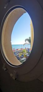 a round window with a view of the beach at Villa Azzurra superbe 2P centrale et vu mer in Menton